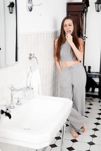 Portrait of smiling young woman sitting in bathroom