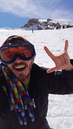 Portrait of happy man gesturing while standing on snowy field at cerler