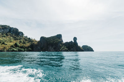 Rock formation in sea against sky