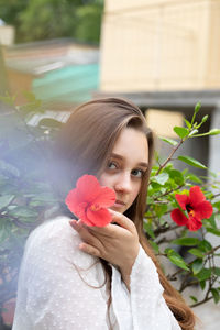 Portrait of young woman holding flower