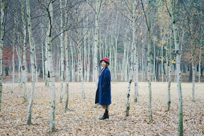 Man standing on tree trunk in forest