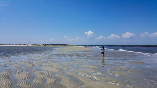 Man standing on beach against clear sky