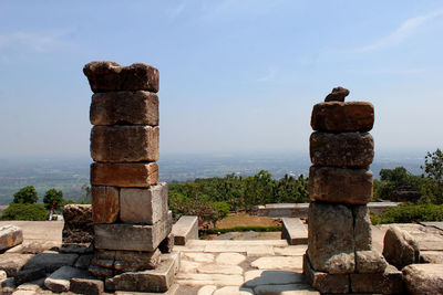 Stone wall at cemetery against sky