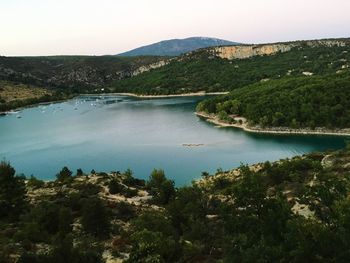 Scenic view of river by mountains against clear sky