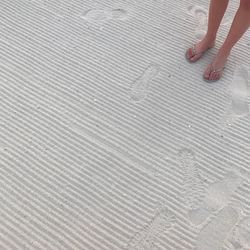 Low section of woman standing on sand