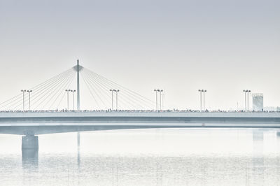 Marathon run on bridge over river against sky