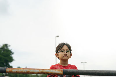 A portrait of young malay boy wearing glasses outdoor.