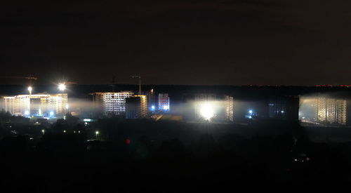 Illuminated city against sky at night