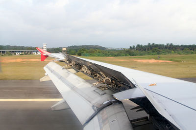 Airplane on airport runway against sky