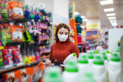 Full length of woman wearing mask at store