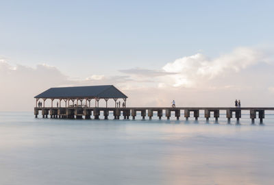 Pier over sea against sky during sunset