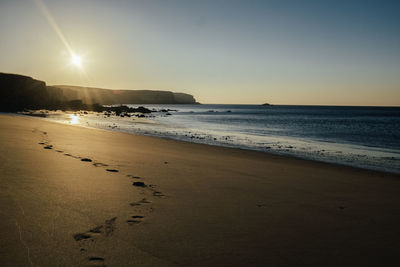 Scenic view of beach against sky during sunset