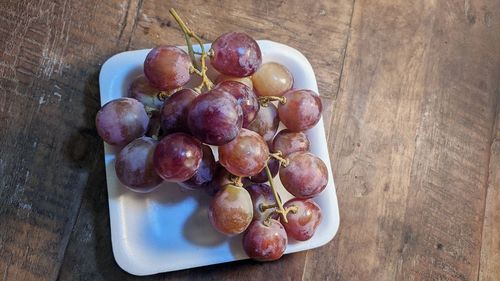 High angle view of grapes in bowl on table