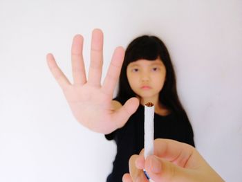 Portrait of baby girl with hand on white background