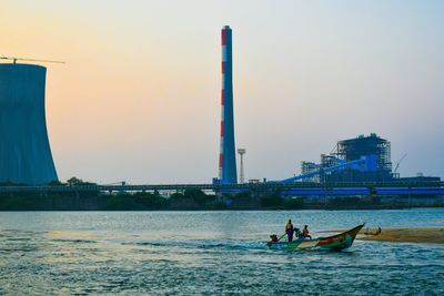 People on sea against clear sky