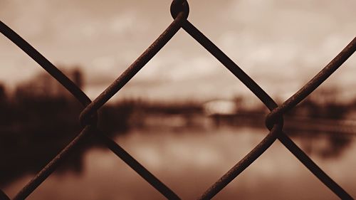 Close-up of chainlink fence against sky