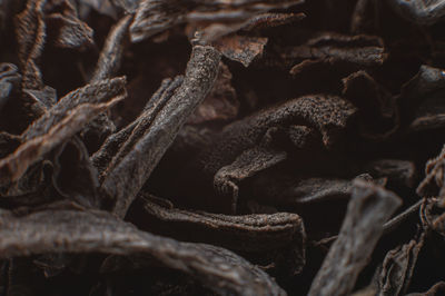 Black loose leaf tea as a background. texture of dry black tea leaves. dark background. extreme