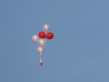 Low angle view of balloons against sky