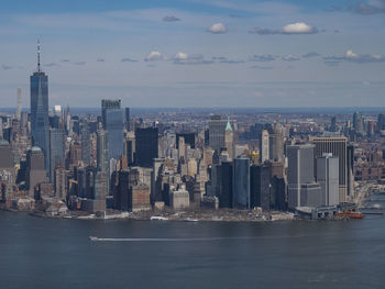 Sea by buildings against sky in city