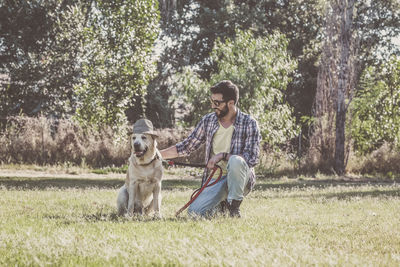 Man and dog on street against trees