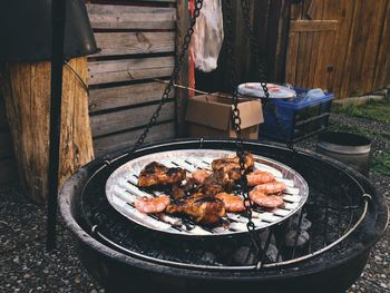 Meat cooking on barbecue grill in yard