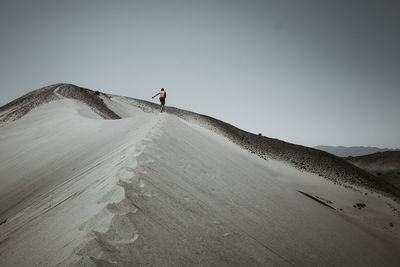 Man on arid landscape against sky