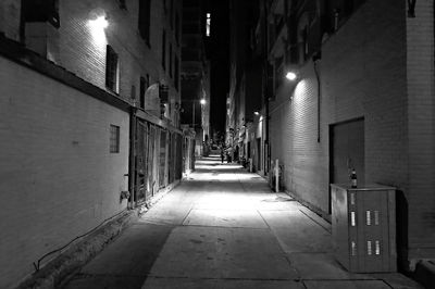 Narrow street amidst buildings at night