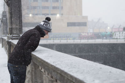 Side view of man standing on snow