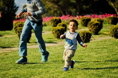 Full length of happy boy playing on grass