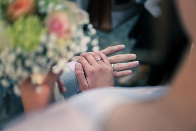 Midsection of couple holding hands at wedding ceremony