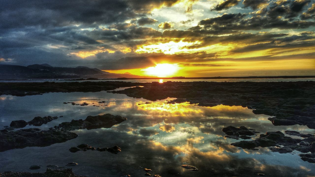 sunset, water, sky, scenics, tranquil scene, beauty in nature, cloud - sky, tranquility, sun, reflection, sea, orange color, nature, idyllic, cloudy, beach, dramatic sky, cloud, shore, horizon over water