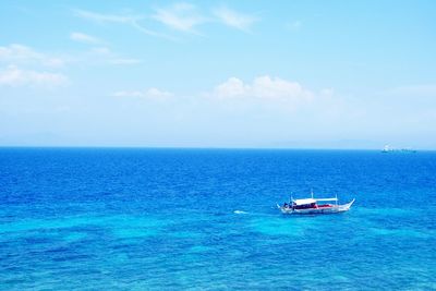 Fishing boat in sea against sky