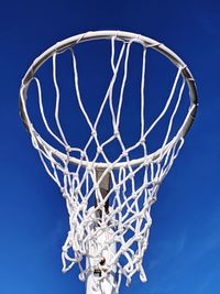 Low angle view of basketball hoop against blue sky