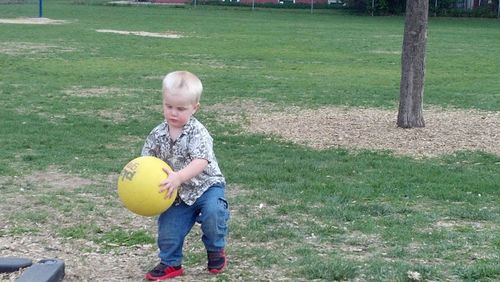 Portrait of boy playing on grassy field