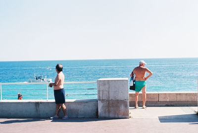 Full length of man standing at sea against clear sky