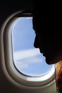 Portrait of mid adult man seen through airplane window