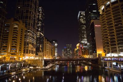 Illuminated cityscape against sky at night