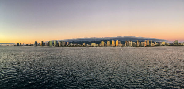 City buildings against clear sky during sunset