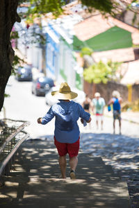 Rear view of woman walking on footpath