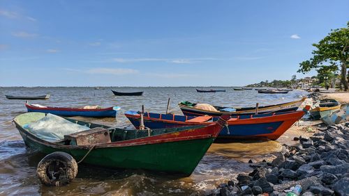 Boats moored in sea against sky