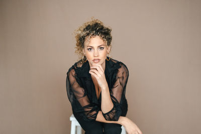 Portrait of young woman against gray background