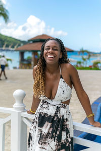 Portrait of young woman standing against sea