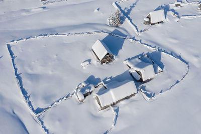 Snow covered remote village, homestead in the mountains. aerial drone view