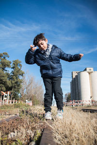 Full length of boy on field against sky