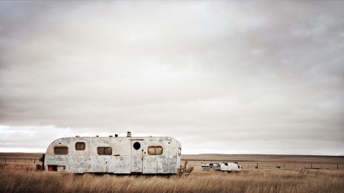 Travel trailer on landscape against sky