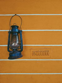 Close-up of lantern hanging on wall