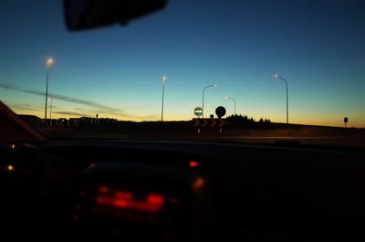 Cars moving on road against blue sky