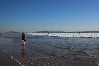 Woman on beach against clear sky