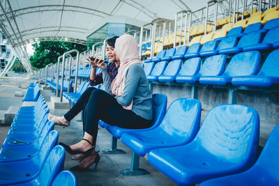 Side view of woman sitting on chair