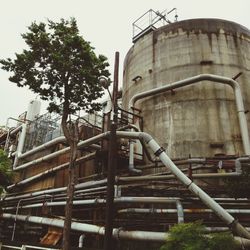 Low angle view of industry against sky